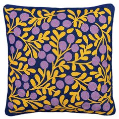 a blue and yellow pillow with purple leaves on the front, against a white background