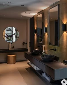 a bathroom with two sinks, mirrors and lights on the wall above them is shown