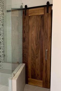 a bathroom with a wooden door and tiled floor