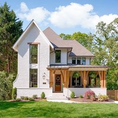 a large white house sitting on top of a lush green field