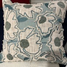 a blue and white pillow sitting on top of a bed