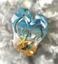 Hand- painted seascape ornament designed to bring the sea to any Christmas tree. Adorned with real sand and seashells. Approximately 5 in. (height) x 4 in. (long). | No shirt, no shoes, no problem! This flip flop ornament is hand- painted with a beautiful seascape, making it the perfect gift for the beach goer, summer lover, or year- round sandal wearer in your life. | 1-800-Flowers Everyday Gift Delivery Unique - Painted Flip Flop Seascape Ornament Ocean Art Painting, Coastal Ornament, Beach Glass Crafts, Resin Ornaments, Beach Ornaments, Shell Crafts Diy, No Shoes, Gift Delivery, Nativity Ornaments