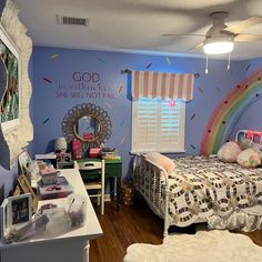 a child's bedroom decorated in blue and pink with rainbows on the walls