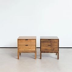 two wooden nightstands sitting next to each other on top of a white floor in front of a wall