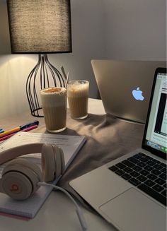 an open laptop computer sitting on top of a desk next to a cup of coffee