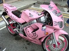 a pink hello kitty motorcycle parked on the street