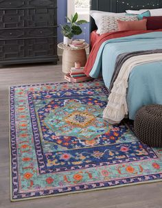 a bedroom with a bed, dresser and rug on the floor in front of it