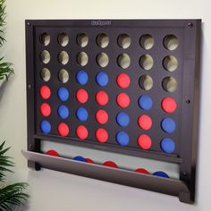 a giant four in a row game with red, white and blue dots on it