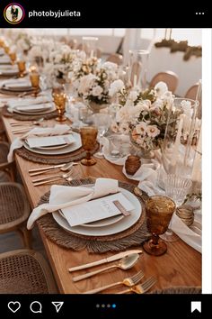 the table is set with white flowers and place settings for guests to sit down at