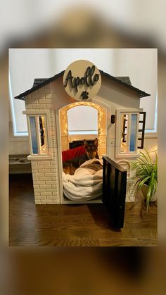 a dog is sitting in his bed made to look like it has been built into the house