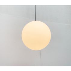 a white light hanging from the ceiling in a room with concrete walls and flooring