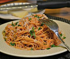 a white plate topped with pasta and parmesan cheese