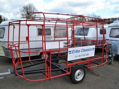 an enclosed trailer is parked in a parking lot with other trailers and campers behind it