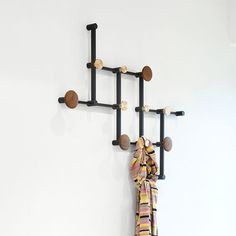 a scarf hanging on a coat rack with hooks and balls attached to the hooks