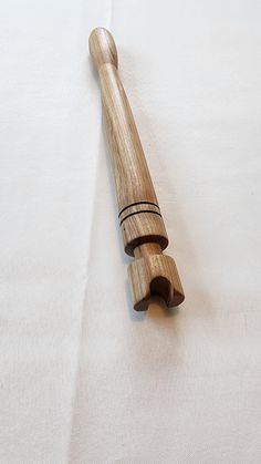 a wooden baseball bat laying on top of a white sheet