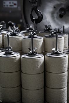 several spools of thread sitting on top of each other in front of a machine