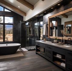 a large bathroom with two sinks and a bathtub next to a big window that looks out onto the mountains