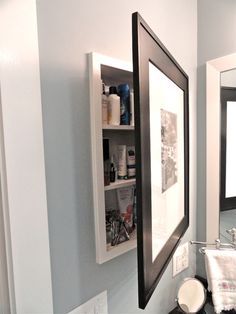 a bathroom with a sink, mirror and shelf above it's toilet paper dispenser