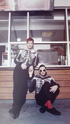 two men in skeleton costumes posing for a photo