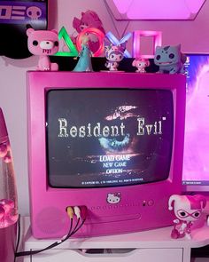 a pink tv sitting on top of a white desk next to a monitor and keyboard