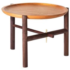 a wooden table with two legs and a round tray on the top that holds a cross