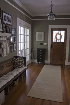 a living room filled with furniture and pictures hanging on the wall next to a door