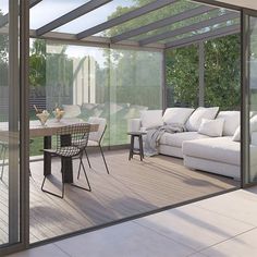 a white couch sitting on top of a wooden floor next to a dining room table