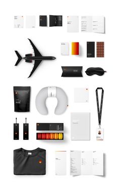 an assortment of stationery items are arranged on a white surface with black and orange accents