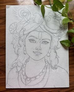 a pencil drawing of a woman's face on a piece of paper next to some leaves