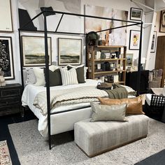 a bed sitting in a bedroom next to a white couch and ottoman on top of a carpeted floor