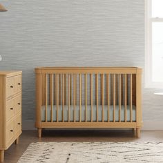 a baby crib next to a dresser in a room