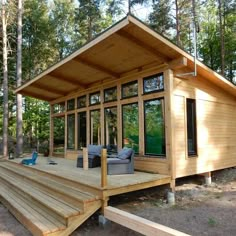 a small wooden cabin in the woods with stairs leading up to it's deck