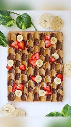 chocolate covered strawberries and banana slices are arranged on top of a square cookie sheet