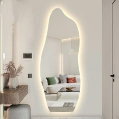 a white living room with a large mirror on the wall