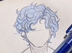 a drawing of a man's head with curly hair on paper next to a blue ballpoint pen