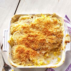 a casserole dish with corn on the side and a spoon next to it