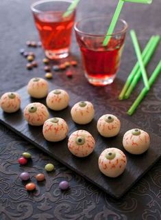 there are many small desserts on the table next to glasses with drinks in them