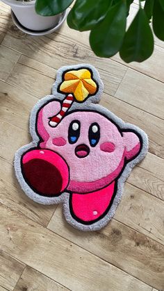 a pink rug with a cartoon character on it and a candy cane sticking out of its mouth