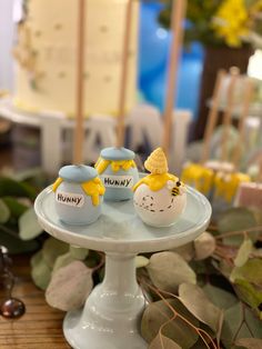 two decorated eggs sitting on top of a cake plate