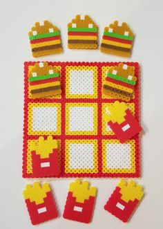 a red and yellow play mat with different pieces of food on it, including hamburgers