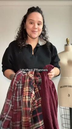 a woman standing next to a mannequin wearing a black shirt and plaid skirt