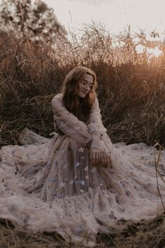 a woman in a dress sitting on the ground