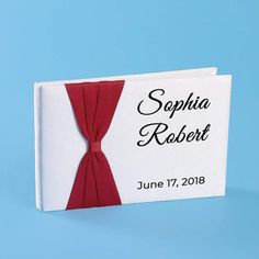 a red tie is on top of a white card with the name and date printed on it