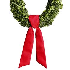 a wreath with a red ribbon tied around it on top of a white background,