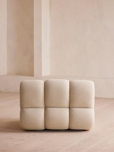 a white couch sitting on top of a hard wood floor next to a tall wall