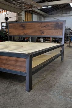 a bed frame made out of metal and wood in a garage with lots of tools