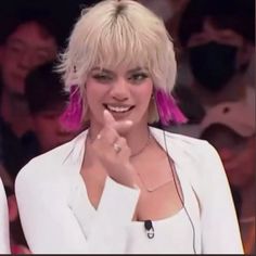 a woman with blonde hair is smiling and posing for the camera in front of an audience