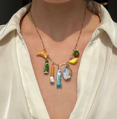 Inspired by the aperitivo experience, this charm necklace features handmade clay pendants of familiar hors d'oeuvres including: croissants, beer, cigarettes, sardines, oysters, olives and more. Each charm is handmade out of lightweight air dry modeling clay, which is then hand-painted and glazed. Buon appetito! This necklace is handmade to order so thank you for your patience! It typically takes me about 8 weeks to ship.  Measurements: The largest charm measures approximately 1.25" in height The chain measures 16.5" Care: To care for your necklace, avoid wearing it in the shower, pool, or ocean as excess exposure to moisture may cause elements of the jewelry to tarnish or degrade. Dinner Necklace, Air Dry Modeling Clay, Italian Necklace, Clay Pendants, Y2k Accessories, Girl Dinner, Rings Necklace, Cute Polymer Clay, Handmade Beaded Necklaces