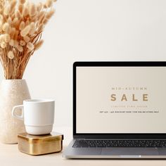 an open laptop computer sitting on top of a desk next to a cup and saucer