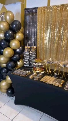 a table topped with lots of gold and black balloons